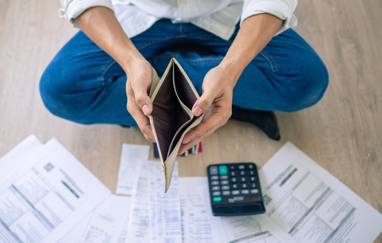 A Businessman Who Is Sitting On The Floor Of The House Opening The Wallet