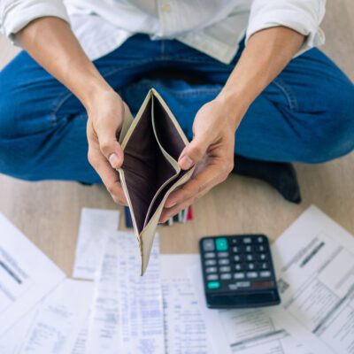 A Businessman Who Is Sitting On The Floor Of The House Opening The Wallet